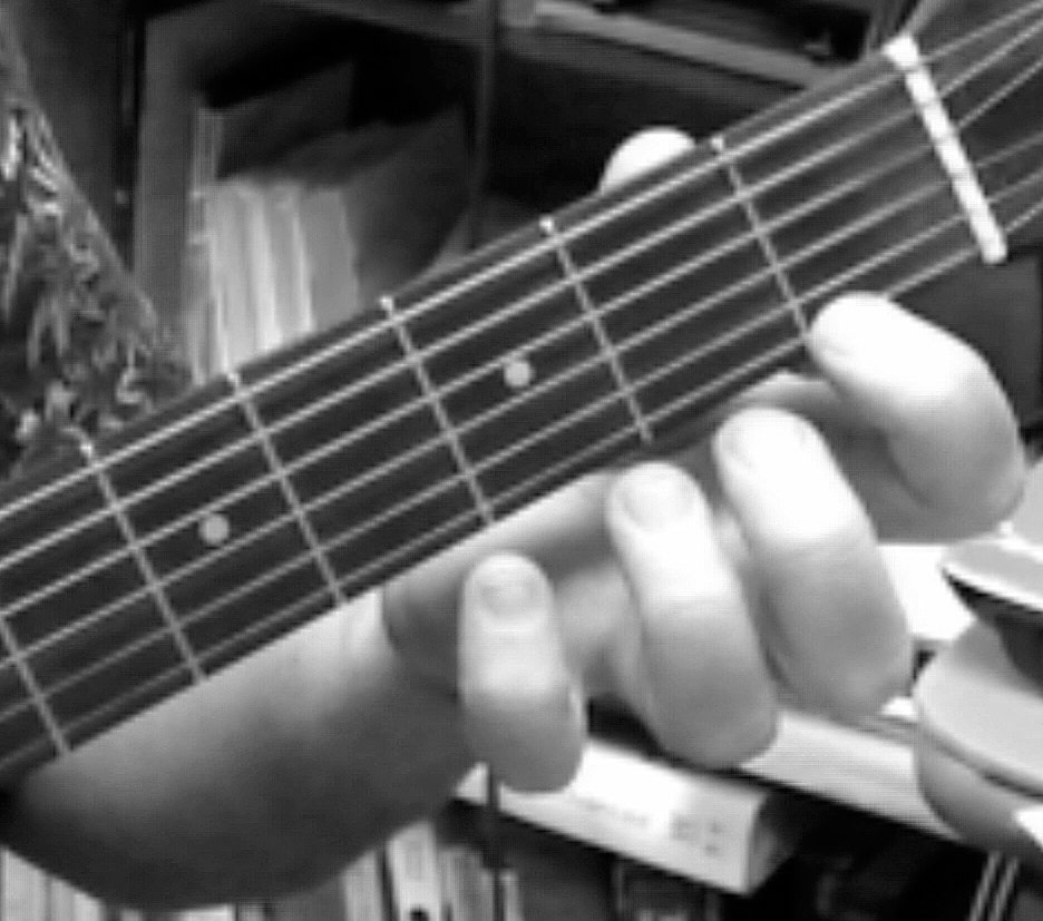 Picture of hand fingering an F on the first string