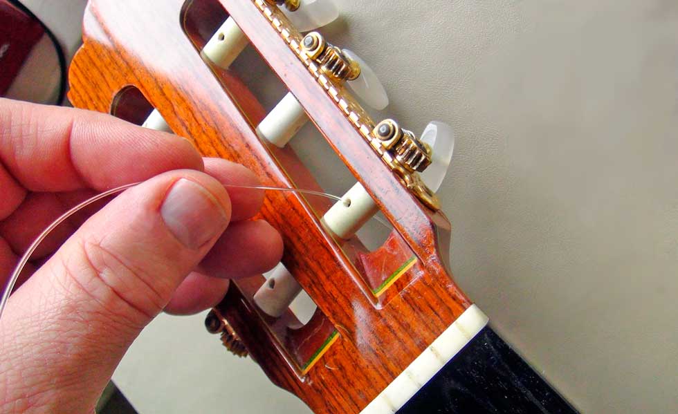 Pass the First String Through the Hole in the Tuning Peg